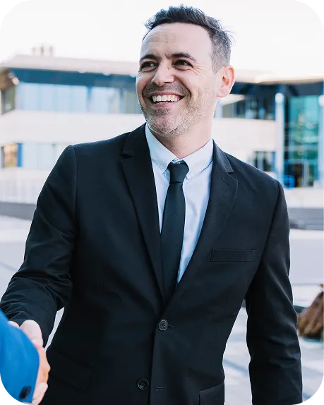 Porteiro de terno sorrindo na entrada de um edifício